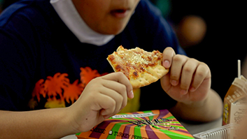 A Post Elementary School student enjoys a piece of pizza during lunch. Wednesdays are pizza days at 